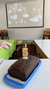 Ein Kuchen mit 5-Jahres-Kerze steht vor einer Leinwand mit dem Film Sister Act